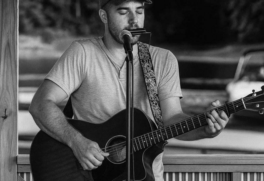 Jacob Cutler performing live with acoustic guitar
and harmonica